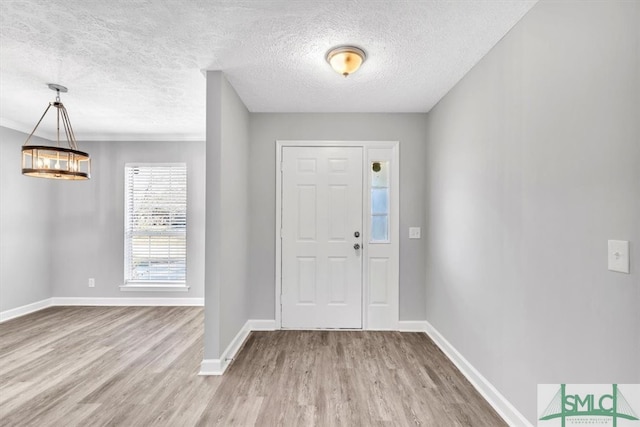 foyer entrance with a textured ceiling and hardwood / wood-style flooring