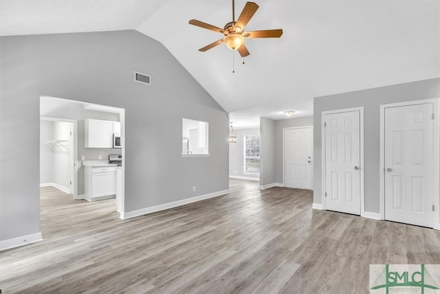 unfurnished living room featuring high vaulted ceiling, light hardwood / wood-style floors, and ceiling fan