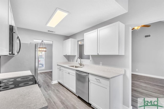 kitchen with light hardwood / wood-style floors, white cabinetry, sink, and appliances with stainless steel finishes