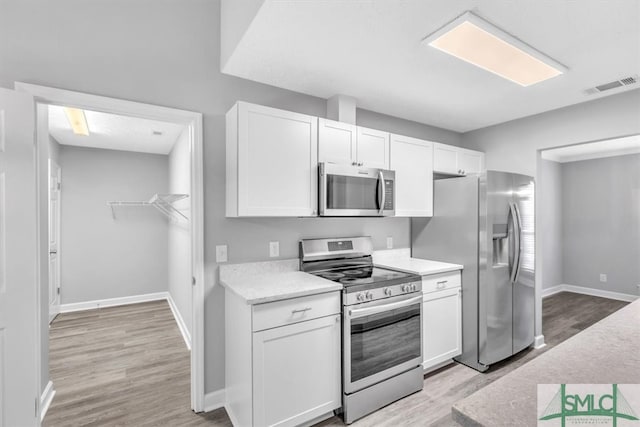 kitchen featuring light hardwood / wood-style floors, white cabinetry, and appliances with stainless steel finishes