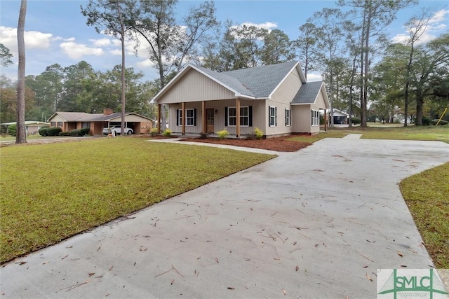 215 Wildwood Dr, Sylvania, GA 30467 - view of front of house featuring driveway, a front lawn, roof with shingles, and covered porch