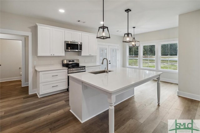 215 Wildwood Dr, Sylvania, GA 30467 - kitchen featuring stainless steel appliances, white cabinets, dark wood finished floors, an island with sink, and recessed lighting