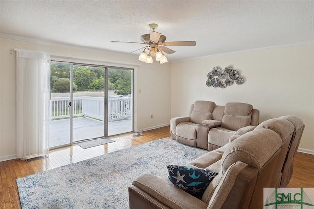 living room featuring crown molding, hardwood / wood-style floors, ceiling fan, and a textured ceiling