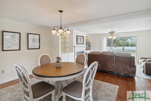 dining space with a textured ceiling, ceiling fan with notable chandelier, dark hardwood / wood-style floors, and crown molding