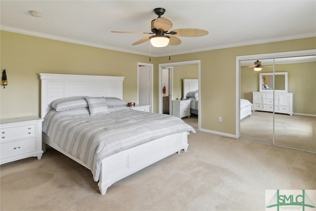 bedroom with ornamental molding, light carpet, ceiling fan, and two closets