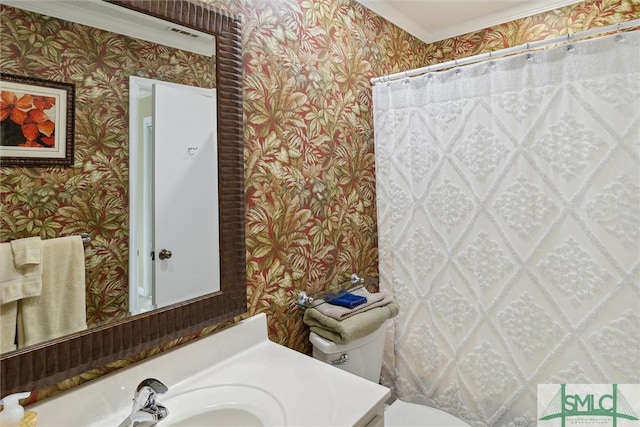 bathroom with ornamental molding, vanity, and toilet