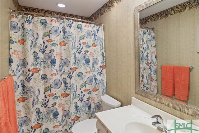 bathroom featuring curtained shower, vanity, and toilet