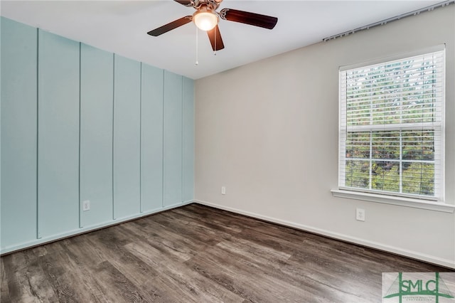 empty room featuring plenty of natural light, dark wood-type flooring, and ceiling fan