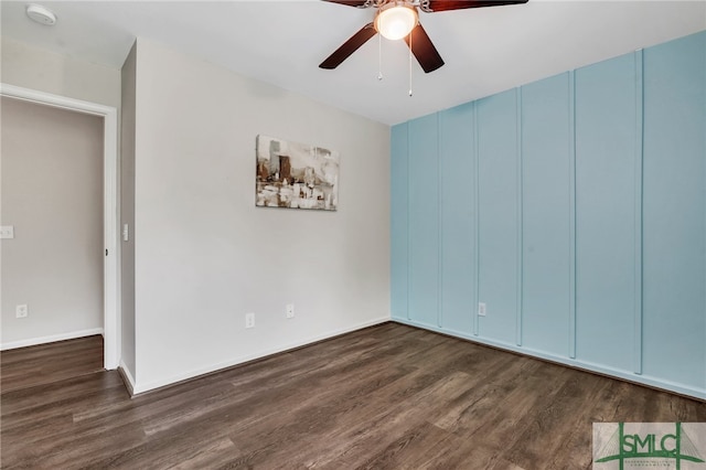 spare room featuring dark wood-type flooring and ceiling fan