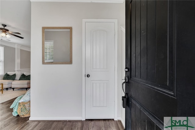 entrance foyer with ornamental molding, hardwood / wood-style floors, and ceiling fan