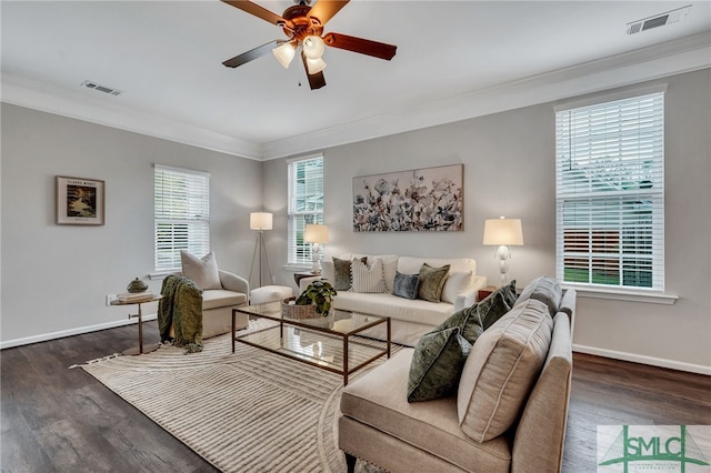 living room featuring ornamental molding, dark wood-type flooring, a healthy amount of sunlight, and ceiling fan