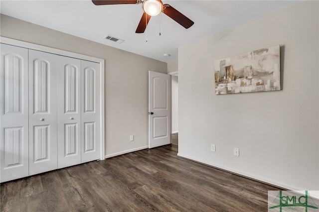 unfurnished bedroom with ceiling fan, dark hardwood / wood-style floors, and a closet