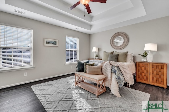 bedroom featuring a tray ceiling, ceiling fan, and dark hardwood / wood-style floors