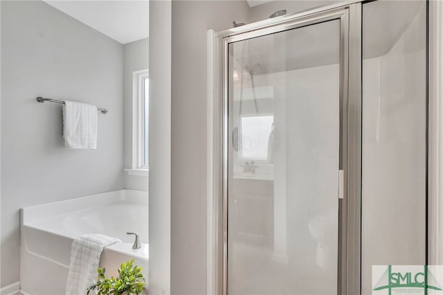 bathroom featuring shower with separate bathtub