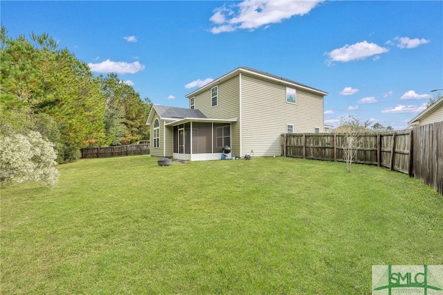 rear view of property featuring a lawn and a sunroom