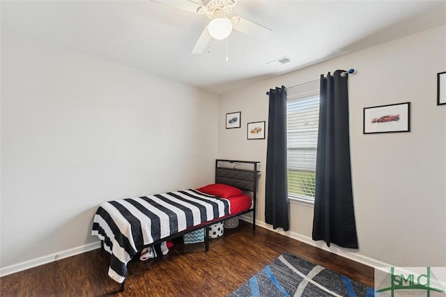 bedroom with ceiling fan, multiple windows, and dark hardwood / wood-style flooring