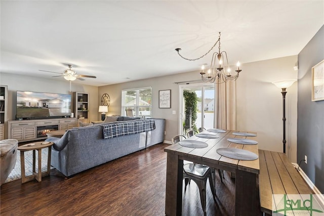 dining room featuring ceiling fan with notable chandelier and dark hardwood / wood-style flooring