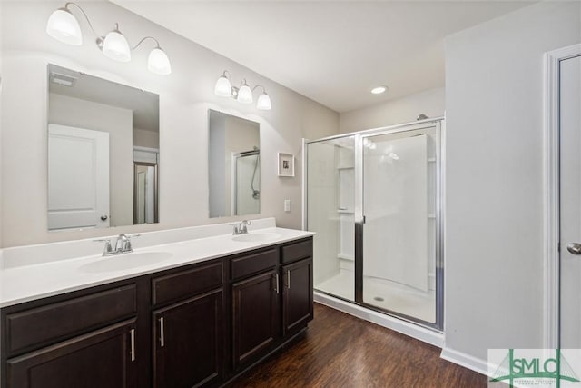 bathroom with hardwood / wood-style floors, walk in shower, and vanity