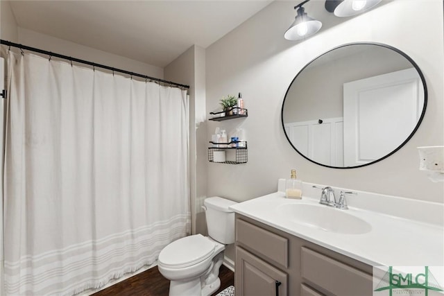 bathroom with toilet, vanity, and hardwood / wood-style flooring