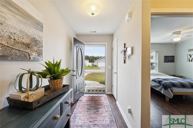 doorway featuring ceiling fan and dark hardwood / wood-style flooring