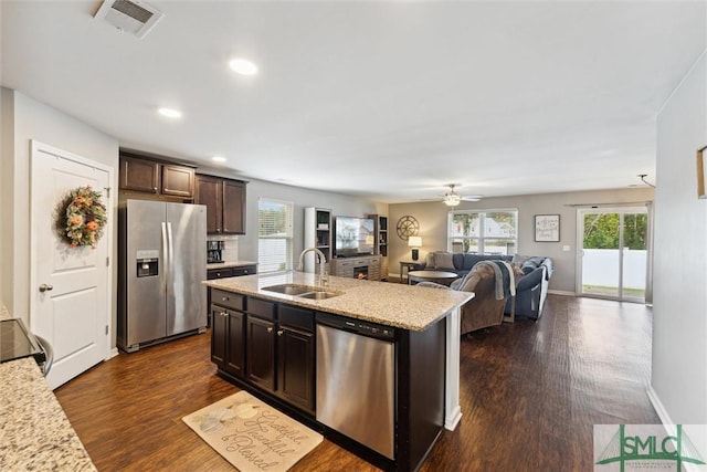 kitchen featuring appliances with stainless steel finishes, an island with sink, dark brown cabinetry, and sink