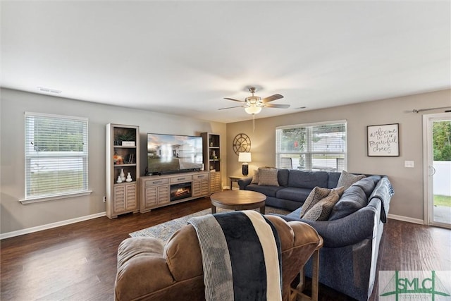 living room featuring ceiling fan, a fireplace, and dark hardwood / wood-style floors