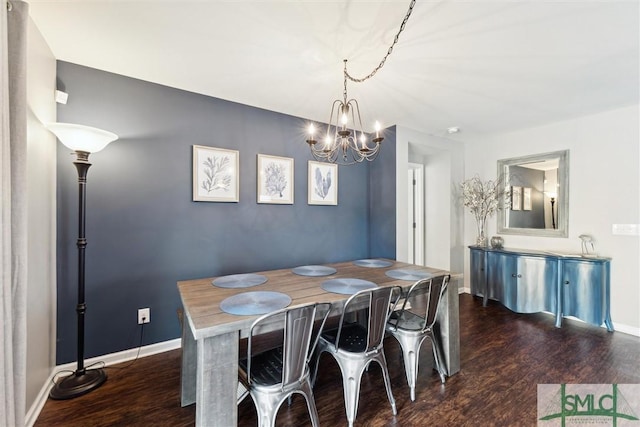 dining space featuring dark hardwood / wood-style floors and a chandelier