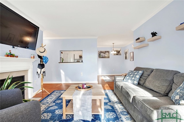 living room with hardwood / wood-style floors, a tiled fireplace, and crown molding