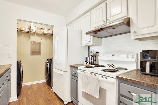 kitchen featuring white cabinets, washing machine and dryer, white appliances, and light wood-type flooring