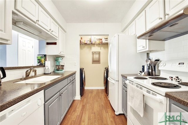 kitchen with white cabinetry, sink, tasteful backsplash, white appliances, and light hardwood / wood-style flooring