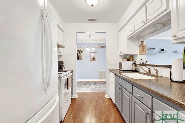 kitchen featuring white cabinetry, light hardwood / wood-style floors, sink, and white appliances