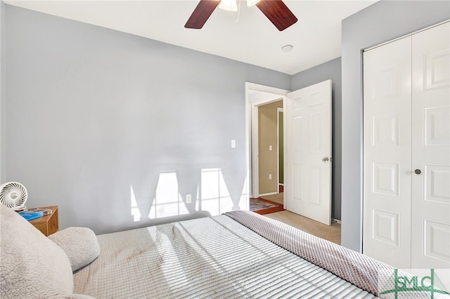 bedroom with ceiling fan, a closet, and light colored carpet