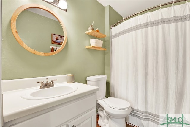 bathroom featuring curtained shower, vanity, and toilet