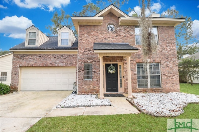 view of property featuring a garage and a front yard