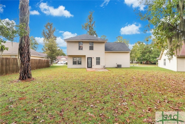 rear view of property featuring a patio, central air condition unit, and a yard