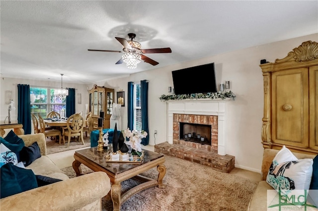 living room featuring a fireplace, ceiling fan with notable chandelier, a textured ceiling, and light colored carpet