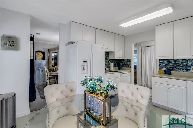 kitchen with sink, white appliances, decorative backsplash, and white cabinets