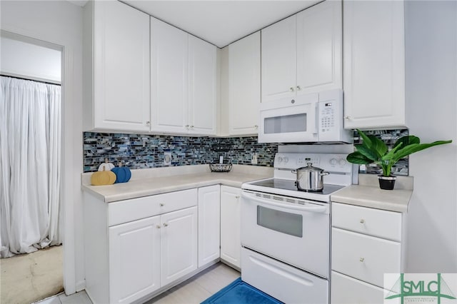 kitchen with white appliances, decorative backsplash, light tile patterned flooring, and white cabinets