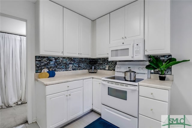 kitchen with white appliances, white cabinetry, and tasteful backsplash