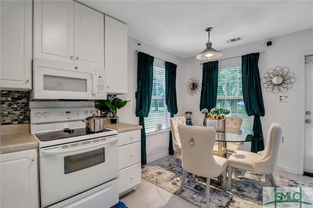 kitchen featuring white cabinetry, decorative backsplash, pendant lighting, and white appliances