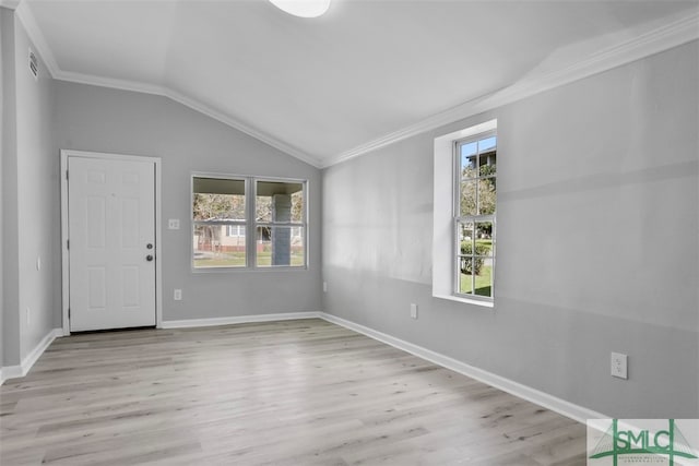 spare room with ornamental molding, vaulted ceiling, and light hardwood / wood-style floors