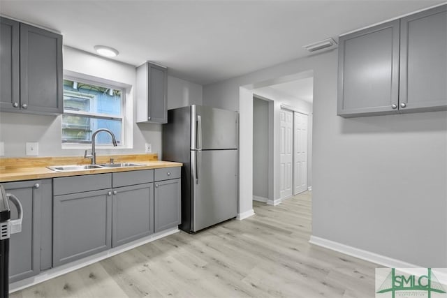 705 W 47th St, Savannah, GA 31405 - kitchen featuring freestanding refrigerator, gray cabinetry, a sink, butcher block counters, and light wood-style flooring