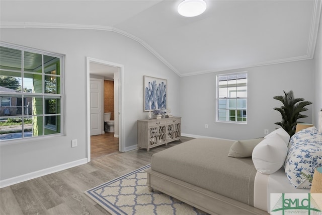 bedroom with ornamental molding, hardwood / wood-style floors, and vaulted ceiling