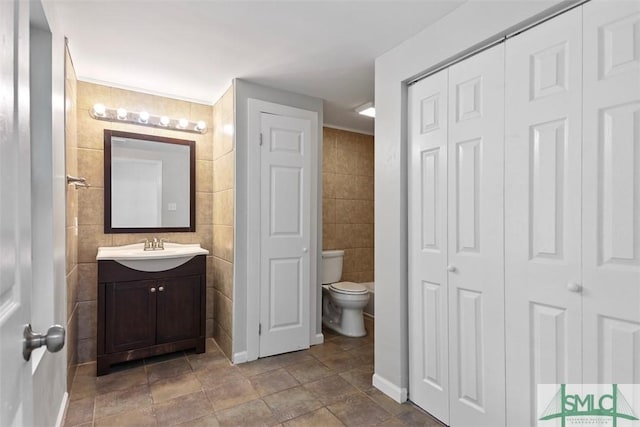 705 W 47th St, Savannah, GA 31405 - bathroom with a closet, toilet, vanity, and tile walls
