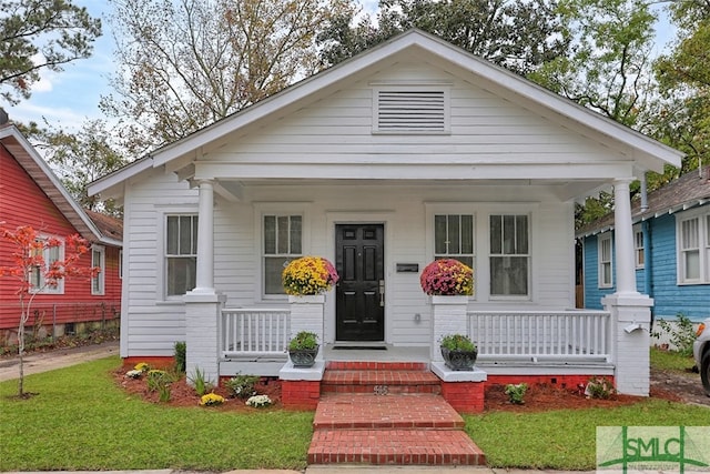 bungalow-style house featuring a front lawn and covered porch