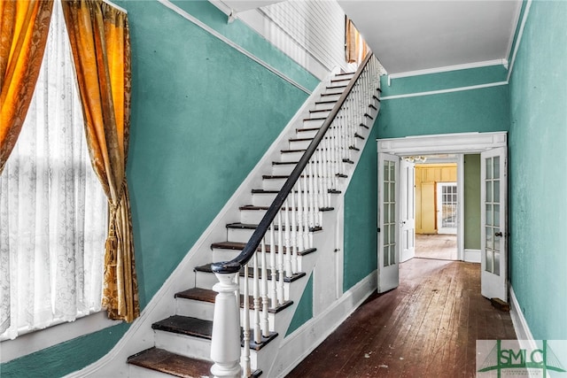 stairs with ornamental molding, french doors, and wood-type flooring