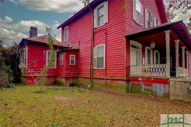 view of property exterior with a porch and a yard