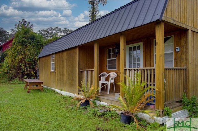 view of outdoor structure with a lawn and a porch