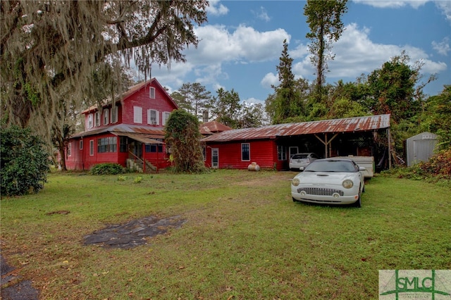 view of front of home with a front lawn, a shed, and a carport