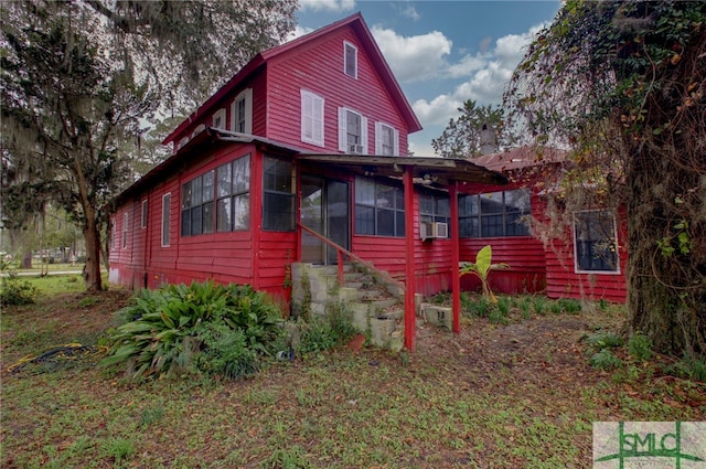 rear view of house featuring a sunroom and cooling unit